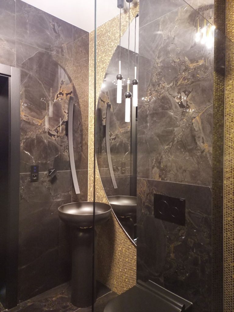 Nowoczesna łazienka z kabiną prysznicową walk-in i czarnymi płytkami marmurowymi