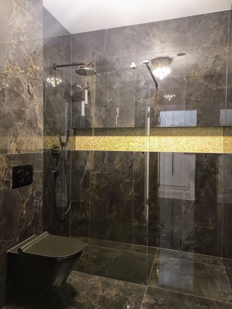 Nowoczesna łazienka z kabiną prysznicową walk-in i czarnymi płytkami marmurowymi